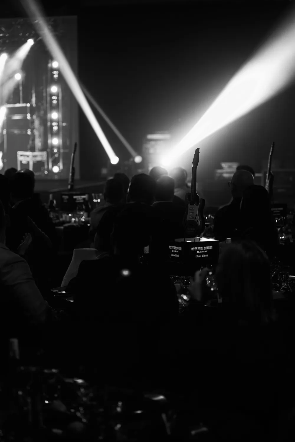 White stage lighting beams crossing a dark event space.