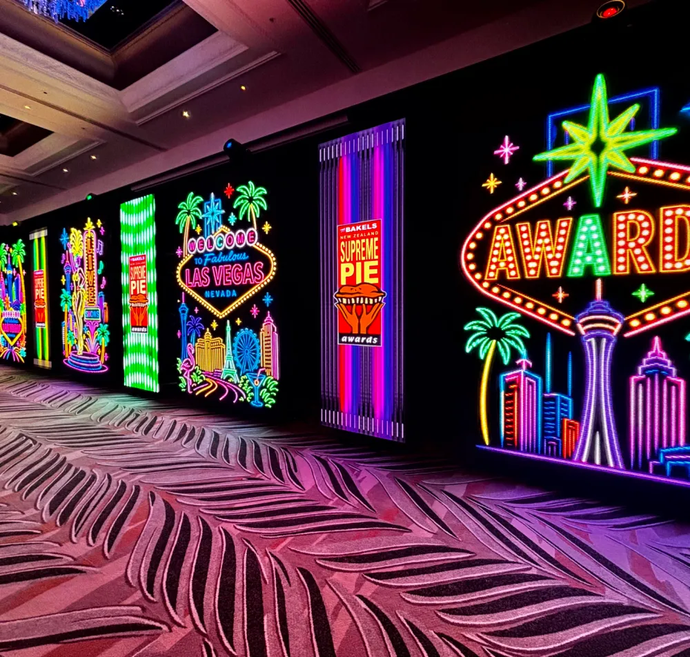 Colourful illuminated display panels lining an awards event space.