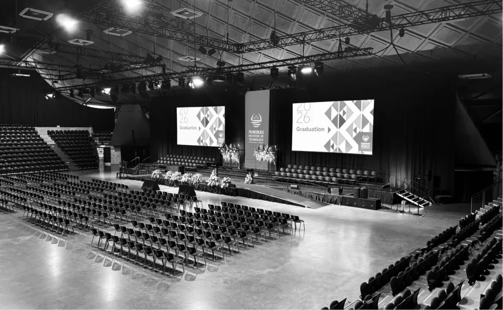 Due Drop Events Centre auditorium with tiered seating, a stage and presentation screens.