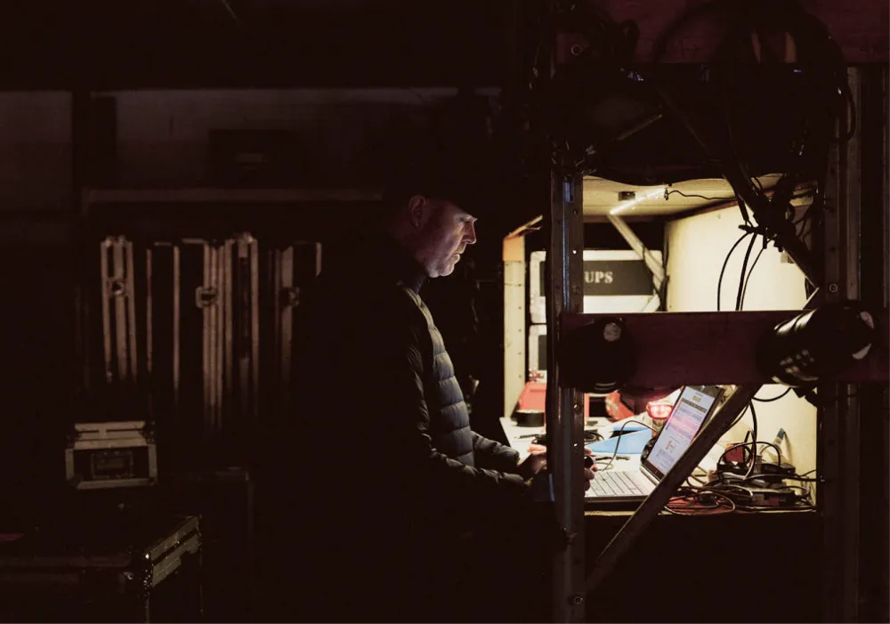 Technician working at an audiovisual equipment rack backstage.