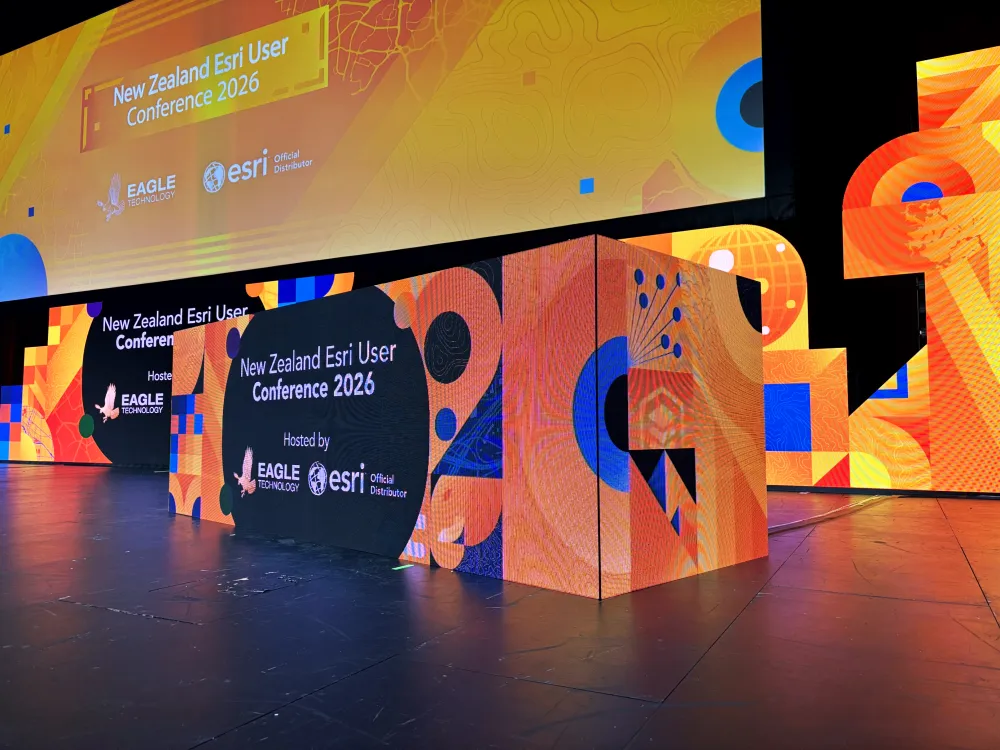 Colourful dimensional lettering and presentation screen on a conference stage.