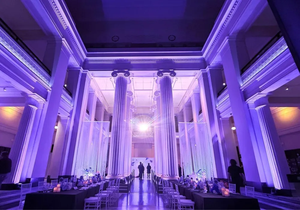 Auckland Museum interior with tall columns lit in purple for an event.
