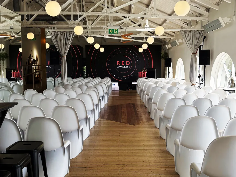Rows of white chairs facing a presentation screen at Mantells.