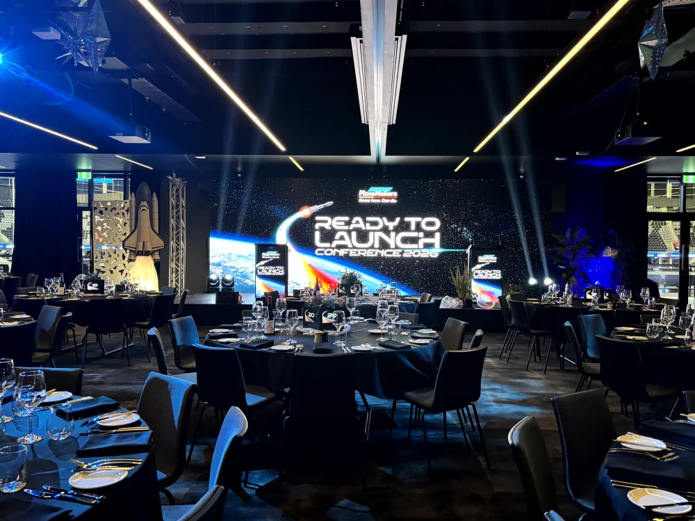 PlaceMakers awards dinner stage with LED screens and overhead beams of light.